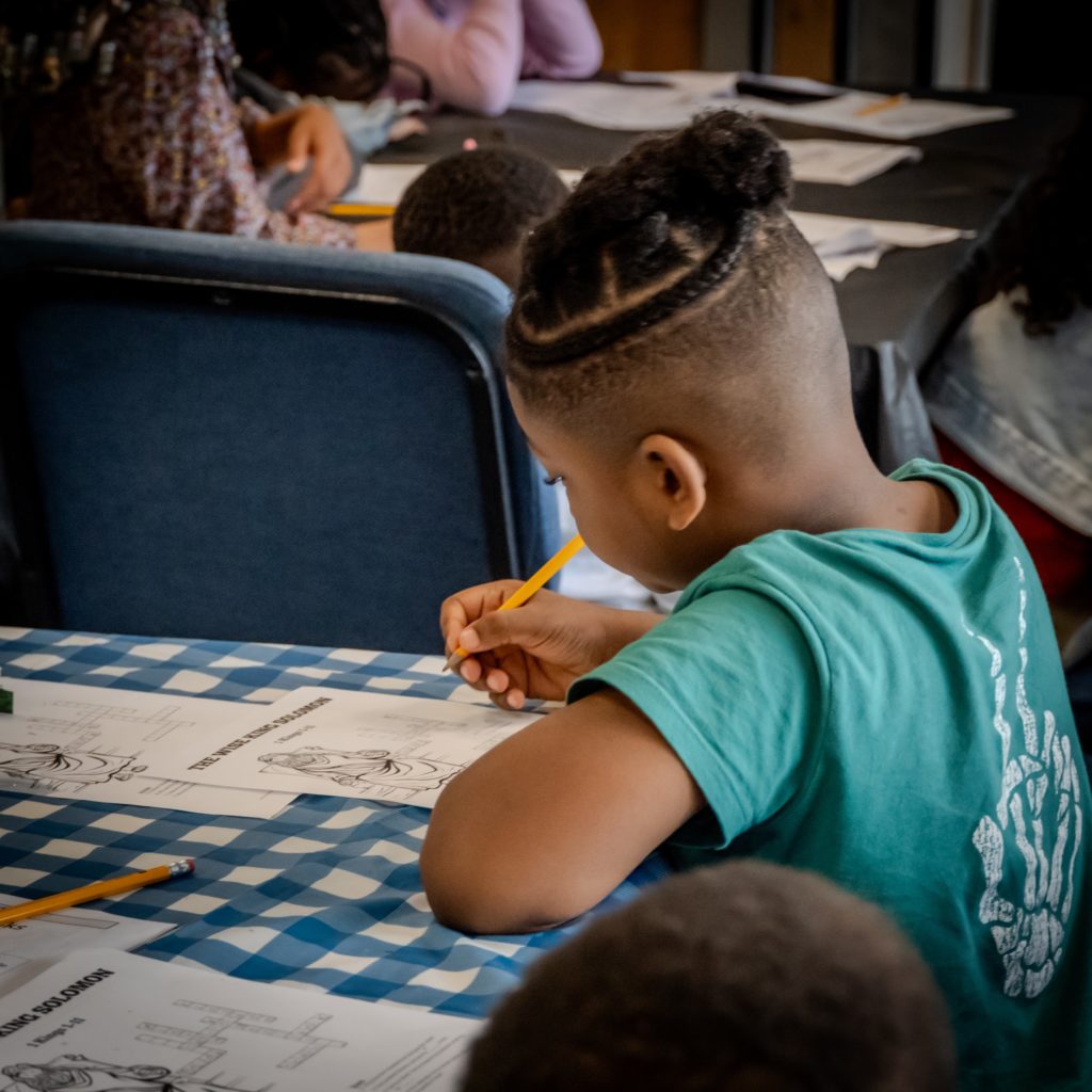 A young boy coloring during a NextGen event