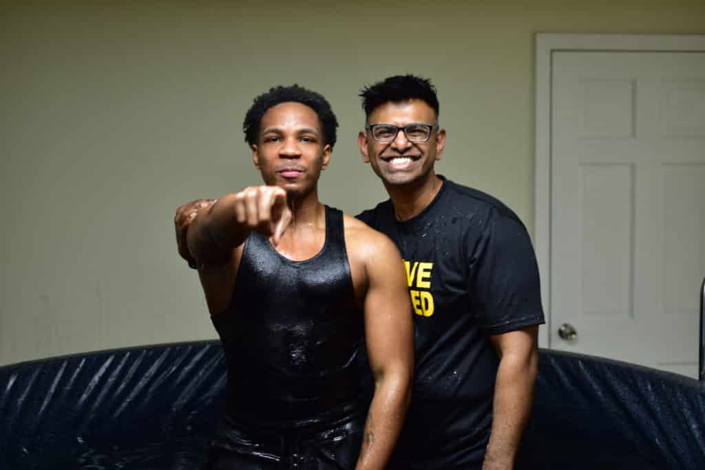 Pastor Bejoy smiling with a newly baptized teenage boy